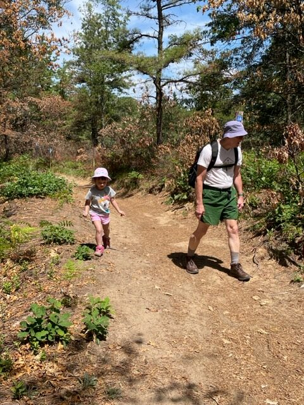 David DeSimone walking on a trail with a child.
